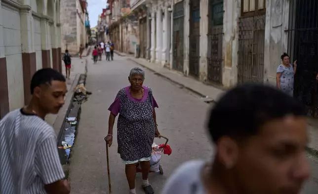 Iris Cecilia Ramirez runs errands in Old Havana, Cuba, Saturday, Feb. 15, 2025. (AP Photo/Ramon Espinosa)