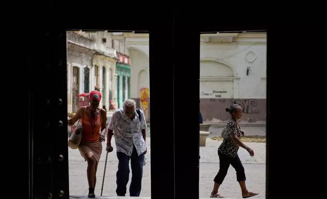 Elderly residents arrive at the Church of the Holy Spirit to receive free meals provided through a church-run program held three times a week, in Old Havana, Cuba, Friday, April 10, 2026. (AP Photo/Ramon Espinosa)
