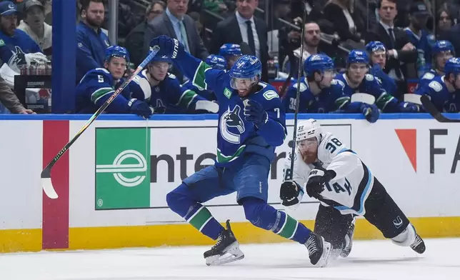 Vancouver Canucks' Pierre-Olivier Joseph (7) stumbles after being checked by Utah Mammoth's Liam O'Brien (38) during the second period of an NHL hockey game, in Vancouver, on Saturday, April 4, 2026. (Darryl Dyck/The Canadian Press via AP)