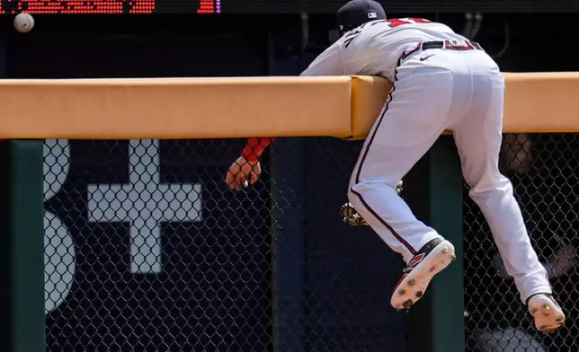 Atlanta Braves right fielder Mike Yastrzemski (18) attempts on Athletics' Shea Langeliers solo home run in the fourth inning of a baseball game, Wednesday, April 1, 2026, in Atlanta. (AP Photo/Mike Stewart)