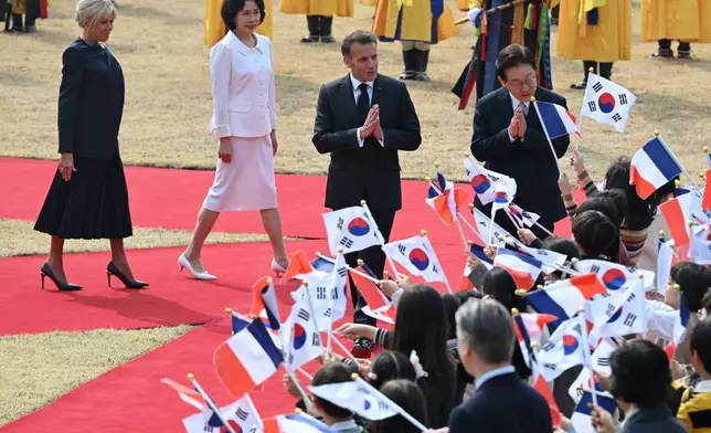 French President Emmanuel Macron, center, his wife Brigitte Macron, left, and South Korean President Lee Jae Myung, right, and his wife Kim Hea Kyung, second left, attend the welcome ceremony at the presidential Blue House in Seoul Friday, April 3, 2026. (Jung Yeon-je /Pool Photo via AP)