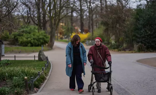 Project coordinator Christine Gruschka, left, talks to Monika Jansen, 85, during a guided tour for people with dementia organized by Malteser Deutschland, part of the international Catholic aid organization Malteser Order of Malta, at the Zoo in Berlin, Germany, Thursday, March 26, 2026. (AP Photo/Markus Schreiber)