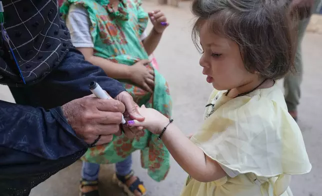 A health worker marks a child's finger after administering a polio vaccine in Lahore, in Lahore, Pakistan, Monday, April 13, 2026. (AP Photo/K.M. Chaudary)