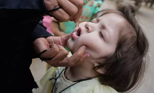 A health worker administers a polio vaccine to a child in Lahore, in Lahore, Pakistan, Monday, April 13, 2026. (AP Photo/K.M. Chaudary)