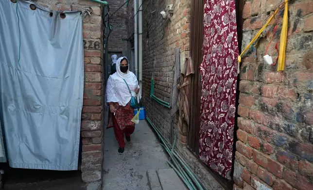 Health workers walk through an ally to administrate polio vaccine among children at a neighbourhood in Lahore, Pakistan, Monday, April 13, 2026. (AP Photo/K.M. Chaudary)