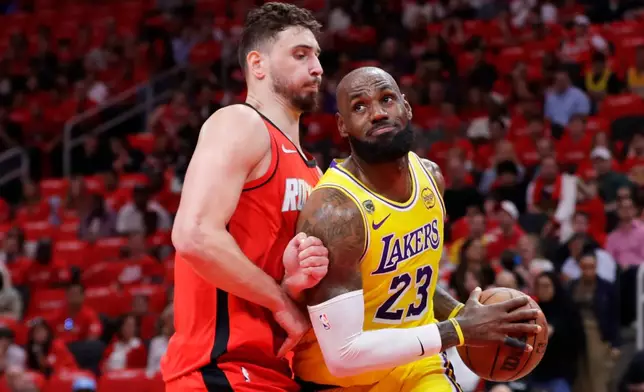 Los Angeles Lakers forward LeBron James (23) drives to the basket in front of Houston Rockets center Alperen Sengun, left, during the first half of Game 3 in a first-round NBA playoffs basketball series Friday April 24, 2026, in Houston. (AP Photo/Michael Wyke)
