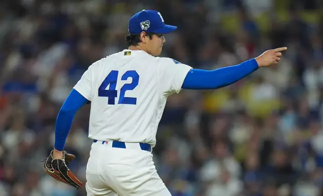 Los Angeles Dodgers starting pitcher Shohei Ohtani points to catcher Will Smith after striking out New York Mets' Bo Bichette to end the sixth inning of a baseball game Wednesday, April 15, 2026, in Los Angeles. (AP Photo/Jae C. Hong)