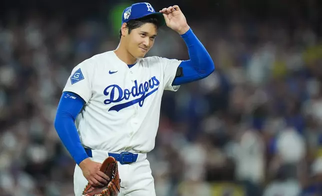 Los Angeles Dodgers starting pitcher Shohei Ohtani adjusts his hat as he walks off the field after the third inning of a baseball game against the New York Mets Wednesday, April 15, 2026, in Los Angeles. (AP Photo/Jae C. Hong)