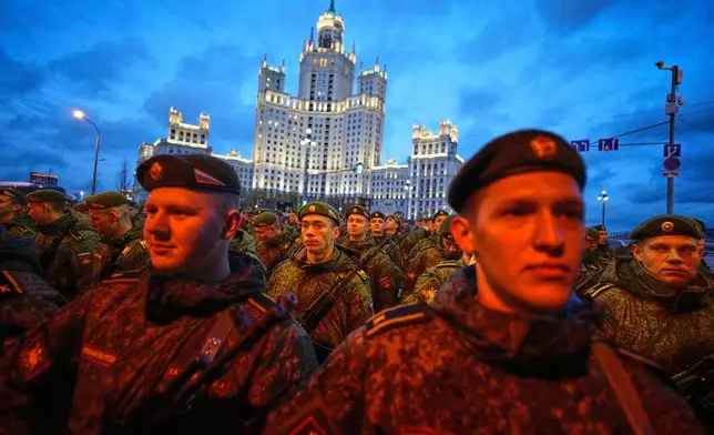 Russian servicemen prepare to march towards Red Square prior to the Victory Day military parade rehearsal in Moscow, Wednesday, April 29, 2026, backdropped by a Stalin stile skyscraper. (AP Photo/Alexander Zemlianichenko)