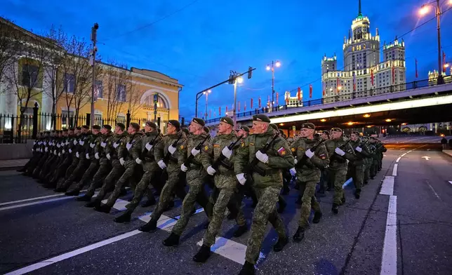 Russian servicemen march towards Red Square prior to the Victory Day military parade rehearsal in Moscow, Wednesday, April 29, 2026, backdropped by a Stalin stile skyscraper. (AP Photo/Alexander Zemlianichenko)