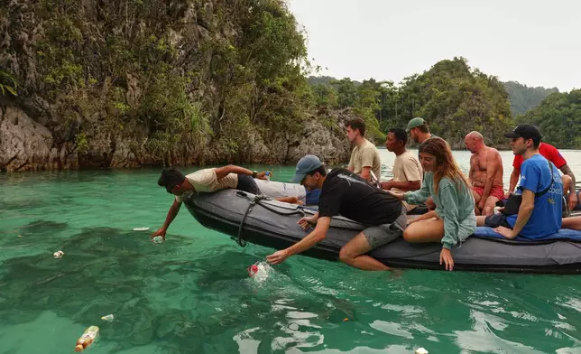 Tourists collect plastic waste from the ocean in Misool, Raja Ampat, Indonesia, Monday, March 2, 2026. (AP Photo/Claudia Rosel)