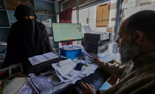 A Muslim woman checks her census registration online at a registration center in Srinagar, Indian controlled Kashmir, April 1, 2026. (AP Photo/Mukhtar Khan)