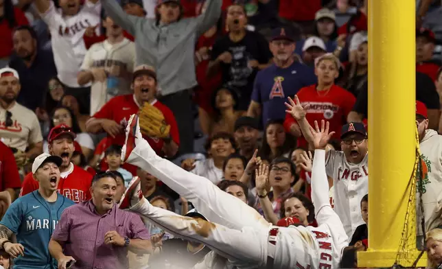 Los Angeles Angels left fielder Jo Adell (7) catches a ball hit by Seattle Mariners' J.P. Crawford during the ninth inning of a baseball game Saturday, April 4, 2026, in Anaheim, Calif. (AP Photo/Caroline Brehman)