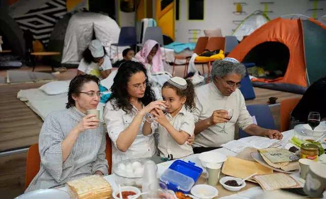 Families celebrate the Passover Eve dinner at a festive table in an underground shelter, in Ramat Gan, Israel, Wednesday, April 1, 2026. (AP Photo/Ohad Zwigenberg)