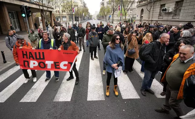 Serbian journalists block the traffic outside the offices of Serbia's President Aleksandar Vucic in Belgrade, Serbia, Wednesday, April 1, 2026, in protest of mounting attacks and pressure on the media. (AP Photo/Darko Vojinovic)