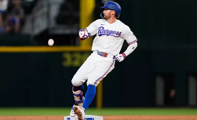 Texas Rangers' Brandon Nimmo reaches the bag after hitting a double in the third inning of a baseball game against the Seattle Mariners Wednesday, April 8, 2026, in Arlington, Texas. (AP Photo/Tony Gutierrez)