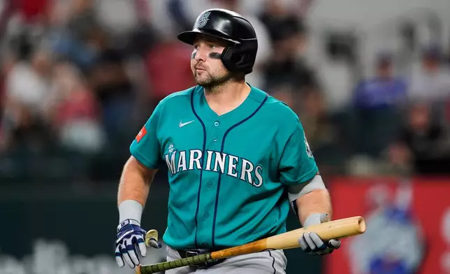 Seattle Mariners' Cal Raleigh walks to the dugout after striking out in the first inning of a baseball game against the Texas Rangers Wednesday, April 8, 2026, in Arlington, Texas. (AP Photo/Tony Gutierrez)