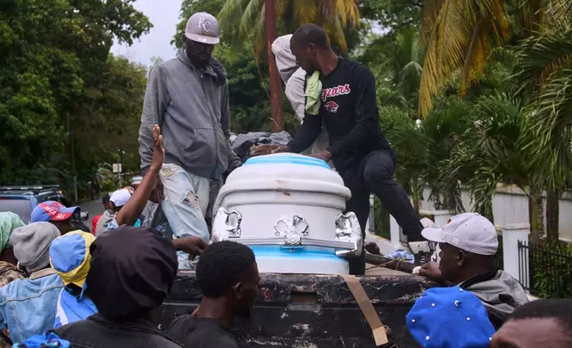 People prepare to transport the body of a relative, a victim of a deadly stampede, to their home, in Milot, Haiti, Sunday, April 12, 2026. (AP Photo/Ketlain Difficile)