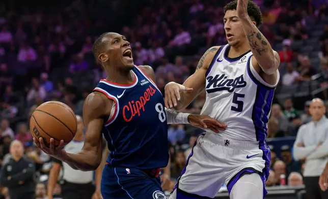 Los Angeles Clippers guard Kris Dunn (8) drives past Sacramento Kings guard Nique Clifford (5) during the first half of an NBA basketball game in Sacramento, Calif., Sunday, April 5, 2026. (AP Photo/Randall Benton)
