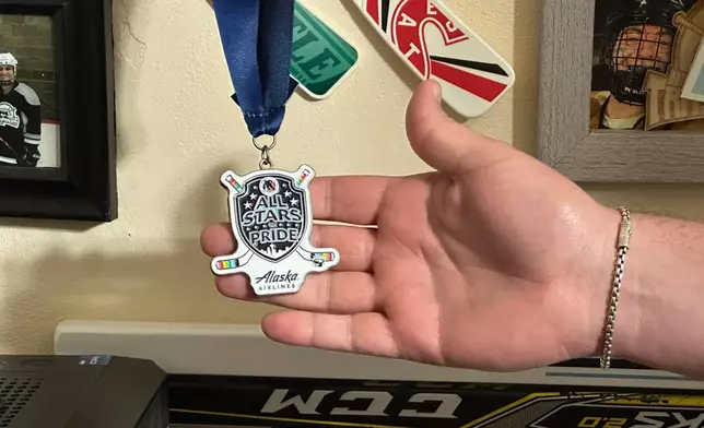 Steven Thompson, co-founder of the Seattle Pride Hockey Association (SPHA), sifts through some of his hockey memorabilia at his home in Des Moines, Wash., Monday, April 27, 2026. (AP Photo/Andrew Destin)