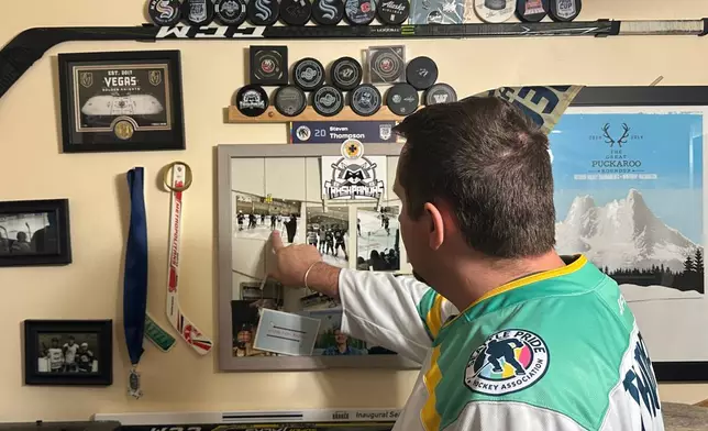 Steven Thompson, co-founder of the Seattle Pride Hockey Association (SPHA), sifts through some of his hockey memorabilia at his home in Des Moines, Wash., Monday, April 27, 2026. (AP Photo/Andrew Destin)
