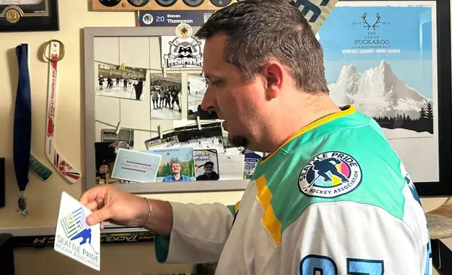 Steven Thompson, co-founder of the Seattle Pride Hockey Association (SPHA), sifts through some of his hockey memorabilia at his home in Des Moines, Wash., Monday, April 27, 2026. (AP Photo/Andrew Destin)