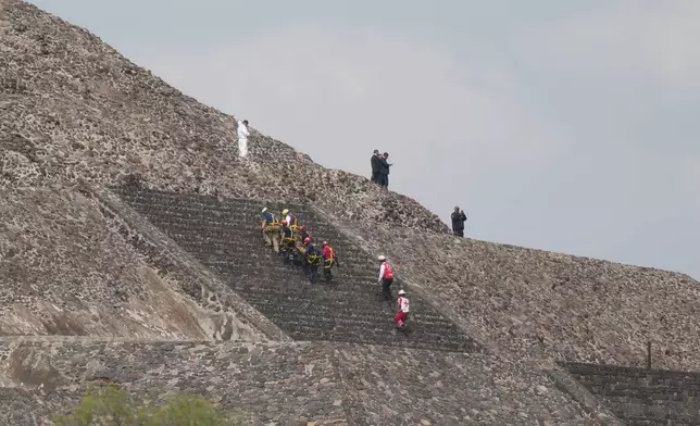Forensic workers remove a victim's body from a pyramid after authorities said a gunman opened fire in Teotihuacan, Mexico, Monday, April 20, 2026. (AP Photo/Eduardo Verdugo)
