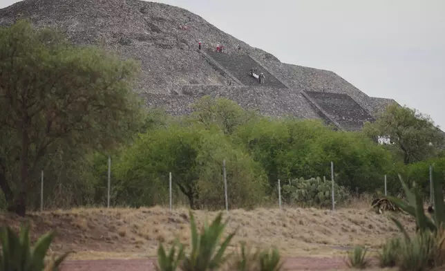 Forensic experts carry the body of a victim down a pyramid after authorities said a gunman opened fire, in Teotihuacan, Mexico, Monday, April 20, 2026. (AP Photo/Eduardo Verdugo)