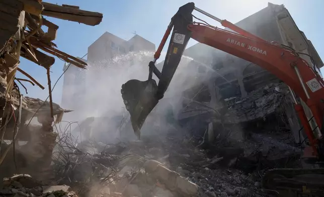 An excavator removes rubble at the site of a strike that, according to a security official at the scene, destroyed half of the Khorasaniha Synagogue and nearby residential buildings in Tehran, Iran, Tuesday, April 7, 2026. (AP Photo/Francisco Seco)