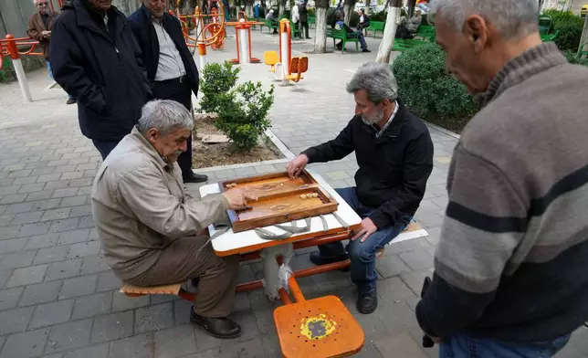 Ali Asghar Nasrulahi, 66, left, a veteran of the Iran-Iraq war, plays backgammon with a friend in a public park in Tehran, Wednesday, April 8, 2026. (AP Photo/Francisco Seco)