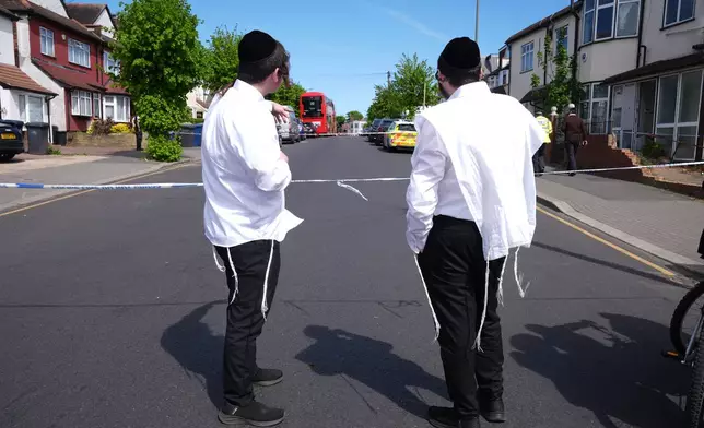 Members of the Jewish community at the scene where two people were stabbed Wednesday April 29, 2026 in a London neighborhood with a large Jewish community and a 45-year-old man was arrested on suspicion of attempted murder over what authorities called an antisemitic attack. (Lucy North/PA via AP)