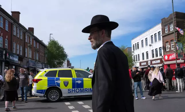 People gather at a road block after two people were stabbed in Golders Green neighbourhood, that has a large Jewish community, in London, Wednesday, April 29, 2026.(AP Photo/Kin Cheung)