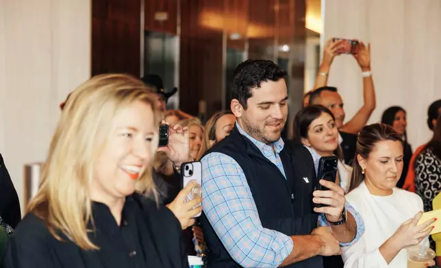 Christal Howard, President and CEO of the Frisco Chamber of Commerce watches with the crowd as the new Fifth Third signage is unveiled at Cowboys Way.