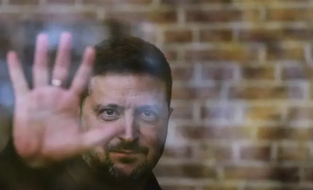 Ukraine's President Volodymyr Zelenskyy waves from behind a glass window after he received the Freedom Medal of the International Four Freedoms Award during a ceremony in Middelburg, Netherlands, Thursday, April 16, 2026. (AP Photo/Peter Dejong)