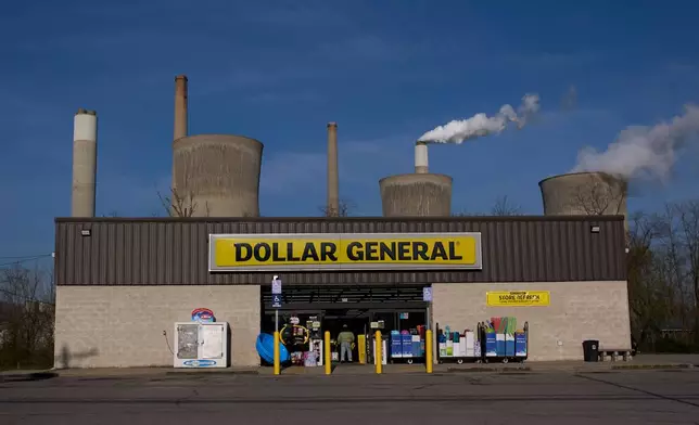 American Electric Power's John Amos coal-fired plant in Winfield, W.Va., stands behind a Dollar General store, Sunday, March 22, 2026, in Poca, W.Va. (AP Photo/Carolyn Kaster)