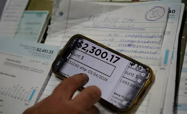 Eric Pinson, manager and resident of the Lock 24 RV Park and Campground, one of two such locations he manages in the area, looks over the business' electric bills, at his home at the campground in Racine, Ohio, Friday, March 13, 2026. (AP Photo/Carolyn Kaster)