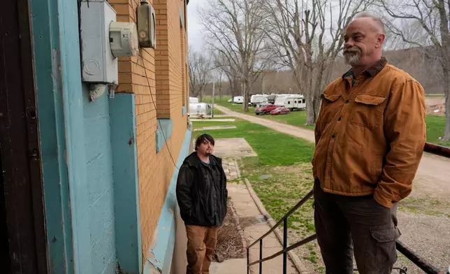 Eric Pinson, right, manager and resident of the Lock 24 RV Park and Campground, is joined by tenant John White Jr., as he looks at an electric meter on the campground in Racine, Ohio, Friday, March 13, 2026. (AP Photo/Carolyn Kaster)