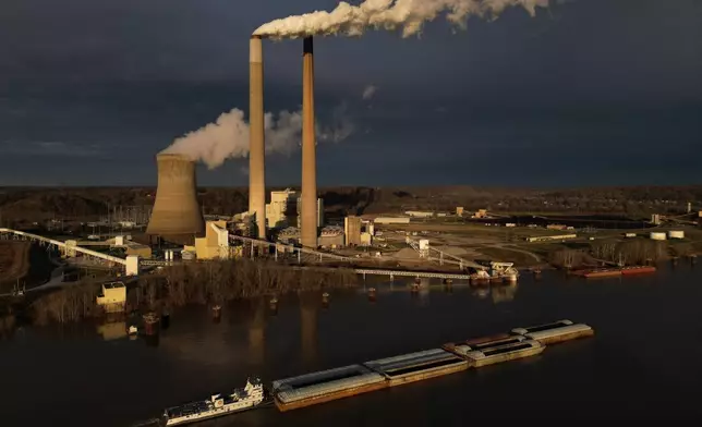 Barges of coal travel along the Ohio River past the coal-fired Mountaineer Power Plant, near New Haven, W.Va., Friday, March 13, 2026. (AP Photo/Carolyn Kaster)