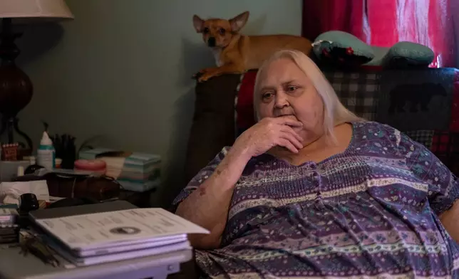 Rebecca Michalski pauses as she talks about electric bills she cannot pay while sitting next to her Chihuahua, Enos, at her home in Rainelle, W.Va., Saturday, March 21, 2026. (AP Photo/Carolyn Kaster)