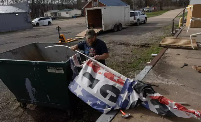 David Horne removes the "Welcome" banner from its pole to put in the dumpster as he works to close up one of the two JCD Bargain and Trade stores, which will consolidate into one location in Ravenswood, W.Va., Friday, March 13, 2026. (AP Photo/Carolyn Kaster)