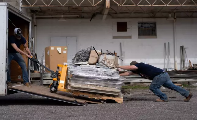 Ed Tierney, left, and David Horne, struggle to load an overloaded pallet onto a truck at they close up one of two JCD Bargain and Trade stores, to consolidate with the other location, in Ravenswood, W.Va., Friday, March 13, 2026. (AP Photo/Carolyn Kaster)