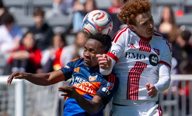 FC Cincinnati midfielder Samuel Gidi, left, and Toronto FC forward Josh Sargent (9) battle for a head ball during the first half of an MLS soccer game in Toronto, Saturday, April 11, 2026. (Frank Gunn/The Canadian Press via AP)