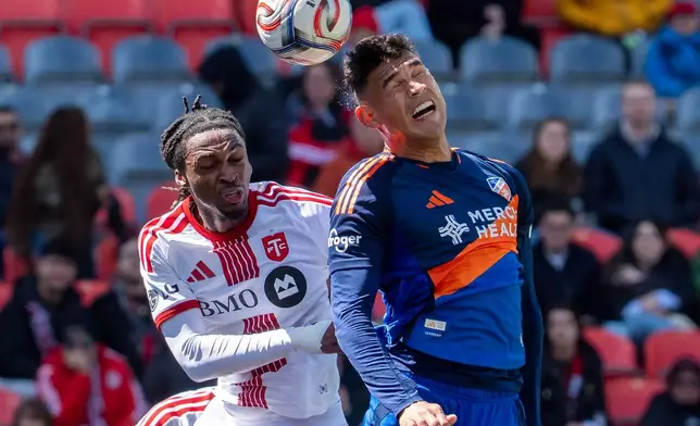 FC Cincinnati defender Gilberto Flores, right, heads the ball over Toronto FC defender Zane Monlouis uring the first half of an MLS soccer game in Toronto, Saturday, April 11, 2026. (Frank Gunn/The Canadian Press via AP)