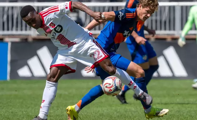 Toronto FC defender Richie Laryea (22) and FC Cincinnati forward Tom Barlow, right, battle for the ball during the first half of an MLS soccer game in Toronto, Saturday, April 11, 2026. (Frank Gunn/The Canadian Press via AP)