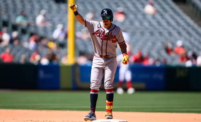 Atlanta Braves shortstop Mauricio Dubón gestures after hitting a RBI double during the fifth inning of a baseball game against the Los Angeles Angels, Wednesday, April 8, 2026, in Anaheim, Calif. (AP Photo/William Liang)
