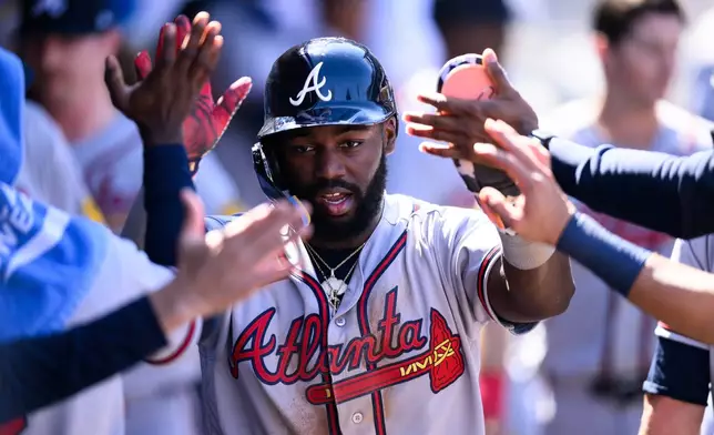 Atlanta Braves' Michael Harris II is greeted by teammates after scoring during the sixth inning of a baseball game against the Los Angeles Angels, Wednesday, April 8, 2026, in Anaheim, Calif. (AP Photo/William Liang)
