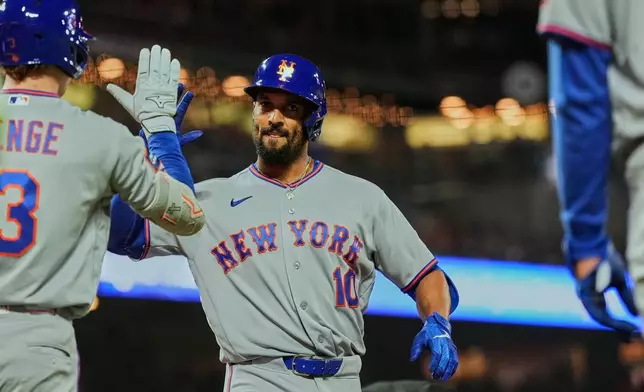 New York Mets' Marcus Semien, center, celebrates with Carson Benge, left, after hitting a two-run home run during the fourth inning of a baseball game against the San Francisco Giants, Friday, April 3, 2026, in San Francisco. (AP Photo/Godofredo A. Vásquez)