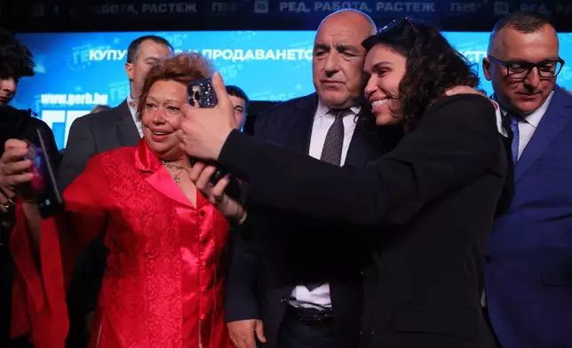 Former three-time conservative Prime Minister Boyko Borissov poses for selfies with supporters at the closing rally of his campaign, in Samokov, Wednesday, April 15, 2026, as Bulgaria heads into an early parliamentary election. (AP Photo/Valentina Petrova)