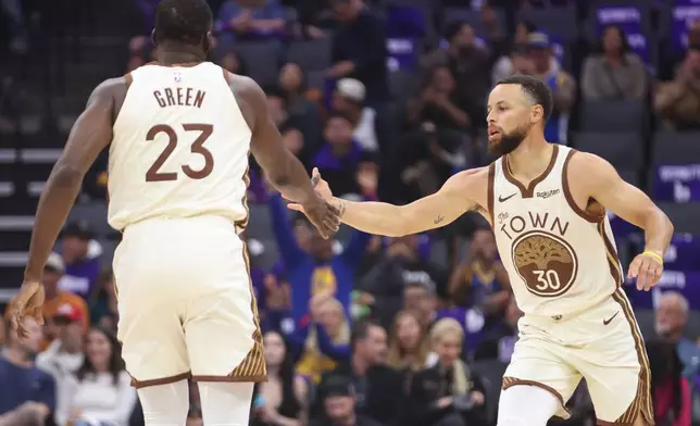 Golden State Warriors guard Stephen Curry (30) high fives Golden State Warriors forward Draymond Green (23) making a three point basket during the first half of an NBA basketball game against the Sacramento Kings, Friday, April 10, 2026, in Sacramento, Calif. (AP Photo/Scott Marshall)
