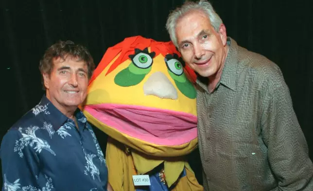 FILE - Puppeteers Sid Krofft, left, and Marty Krofft stand next to H.R. Pufnstuf, one of their many creations, at an auction in Beverly Hills, Calif., on Aug. 23, 1998. (AP Photo/John Hayes, File)